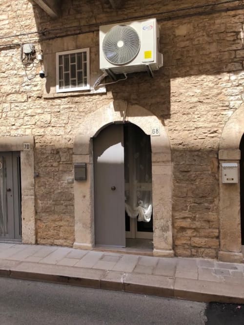 Ingresso di edificio in pietra con numero 68, unità di climatizzazione in alto, appartamento Via Fiore a Terlizzi, Italia