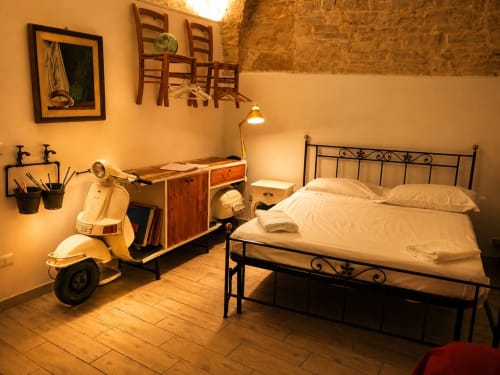 Camera accogliente a Terlizzi con decoro Vespa, letto in ferro, scrivania e illuminazione calda