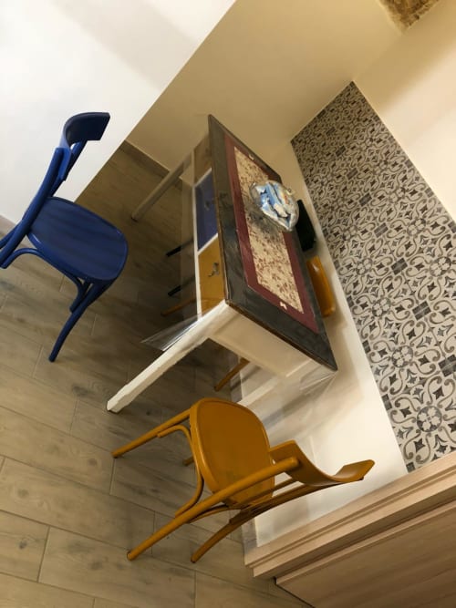Moderna camera presso La piccola casa di Tania a Terlizzi con sedie blu e arancioni, decorazioni murali e motivi geometrici