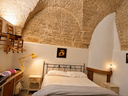 Camera accogliente a La piccola casa di Tania a Terlizzi con volte in pietra a vista, letto in metallo e illuminazione calda