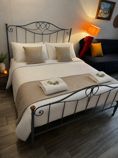 Camera da letto elegantemente arredata a La piccola casa di Tania a Terlizzi con letto in ferro battuto, biancheria bianca e atmosfera calda