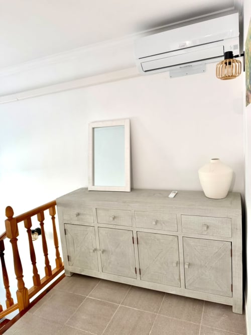 Cómoda de madera clara con jarrón decorativo en la cabaña Casa Mar Blau de Stay Gest Valencia, con aire acondicionado arriba