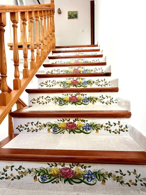 Escalera de madera con peldaños de azulejos florales con rosas rosadas y flores azules, cabaña Casa Mar Blau en Valencia