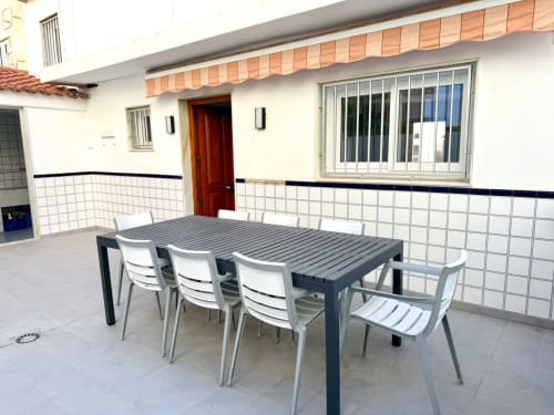 Terraza de comedor al aire libre en Casa Mar Blau de Valencia con mesa, sillas y vistas al mar