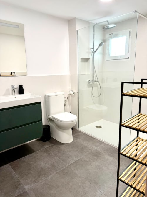 Baño moderno en la casita Casa Mar Blau de Stay Gest Valencia con accesorios blancos, ducha, tocador verde y litera