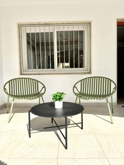 Zona de estar en la terraza de la casa rural Casa Mar Blau en Valencia con sillas verdes, mesa redonda negra y maceta