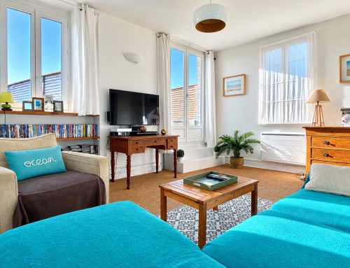 Appartement côtier lumineux avec accents turquoise, vue mer, mobilier en bois et espace divertissement aux Paris Normands