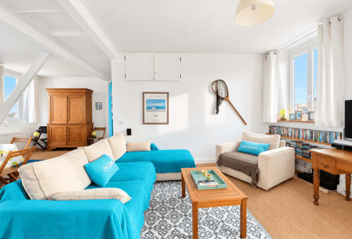 Lumineux séjour normand avec canapé turquoise, mobilier bois, vue mer et équipements modernes