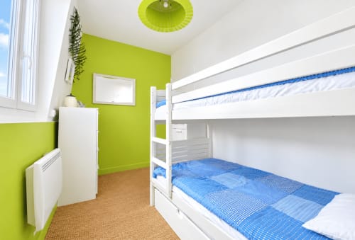 Chambre avec lits superposés vert citron et blanc aux Paris Normands, Boulogne, linge de lit bleu et sol en liège