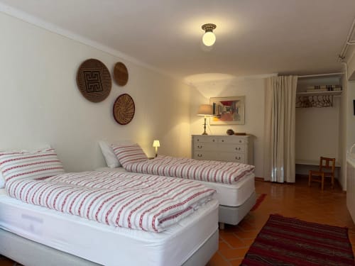 Quarto duplo com roupa de cama às riscas vermelhas na Quinta da Mata de Baixo em Ferreira do Zêzere, Portugal