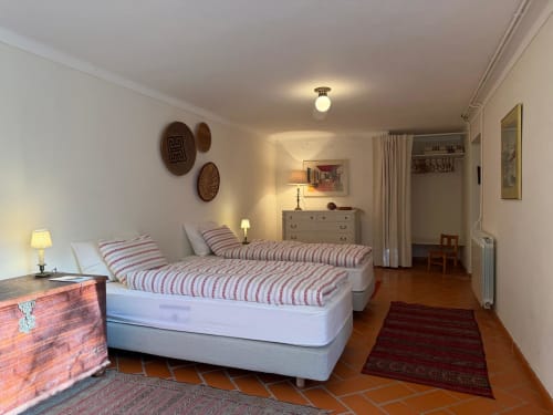 Espaçoso quarto duplo na Quinta da Mata de Baixo com cama de colunas, piso em madeira e vista para o jardim em Ferreira do Zêzere