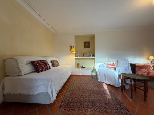 Quarto luminoso na Quinta da Mata de Baixo com duas camas, pisos em terracota e vista de jardim em Ferreira do Zêzere