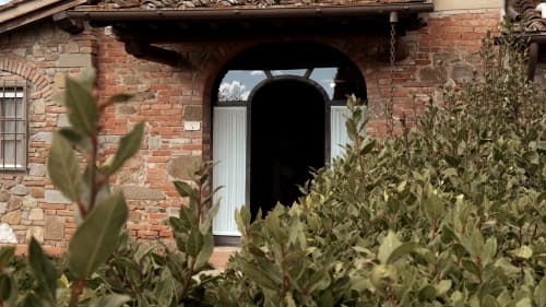 Ingresso ad arco in mattoni all'appartamento Leonardo a Borgo di Erboli, Cavriglia, con piante mediterranee