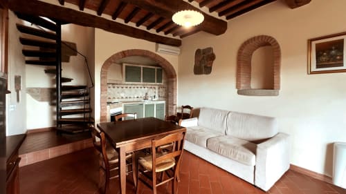 Appartamento Leonardo a Borgo di Erboli a Cavriglia con arcate in mattoni rustici, scale a chiocciola in legno, pavimenti in cotto e