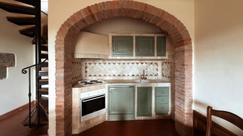Cucina dell'appartamento Leonardo a Borgo di Erboli a Cavriglia con volta in mattoni, mobili verdi e tradizionale rivestimento in piastrelle