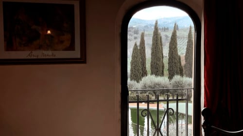 Vista dall'appartamento Leonardo a Borgo di Erboli: cipressi e colline toscane attraverso l'arco della porta