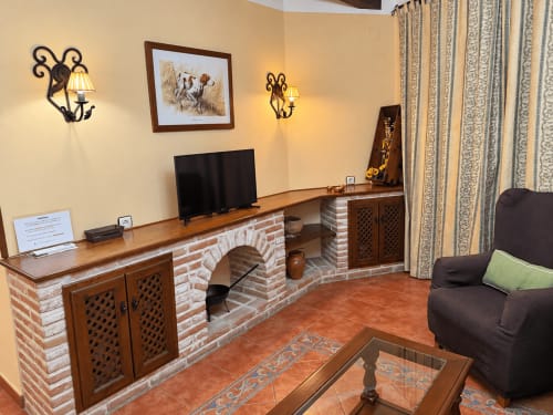 Acogedor salón de apartamento en Oropesa, Toledo con chimenea, TV, cómodos muebles y decoración tradicional