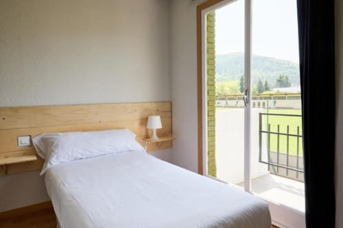 Luminosa habitación doble en Hotel del Trueno en Ezcaray con vistas a las montañas desde el balcón