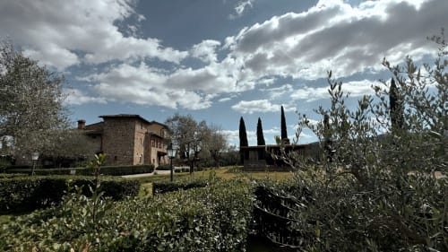 Borgo di Erboli, tenuta rurale a Cavriglia con villa in pietra, cipressi, uliveti e cielo drammatico