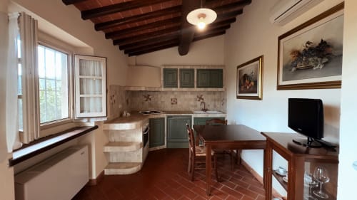 Appartamento Galileo a Borgo di Erboli, Cavriglia: cucina, tavolo da pranzo, TV, travi a vista, pavimenti in terracotta