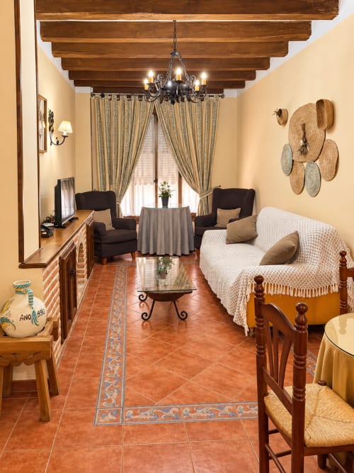 Amplio dormitorio en el hotel La Posada de Oropesa, Toledo con vigas de madera, chimenea y decoración española tradicional