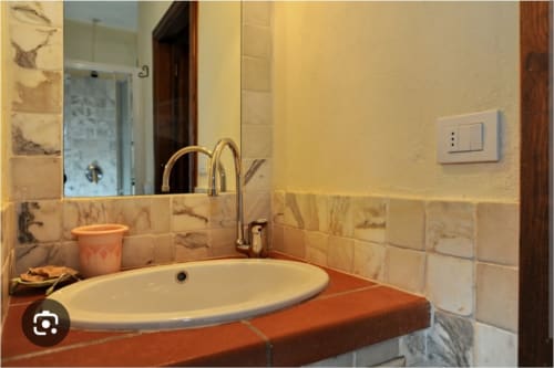 Lavabo in marmo e bacino in ceramica arrotondata nell'appartamento Tommaso a Borgo di Erboli, Cavriglia