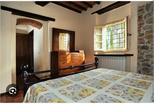 Camera da letto Tommaso presso Borgo di Erboli B&B a Cavriglia con letto in ferro battuto e cassettone in legno