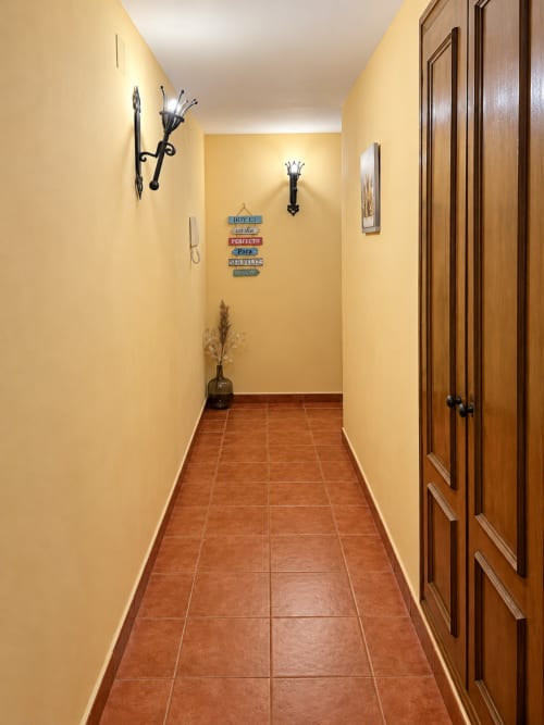 Pasillo en Apartamentos Turísticos La Posada, Oropesa Toledo con baldosas de barro cocido y paredes amarillas