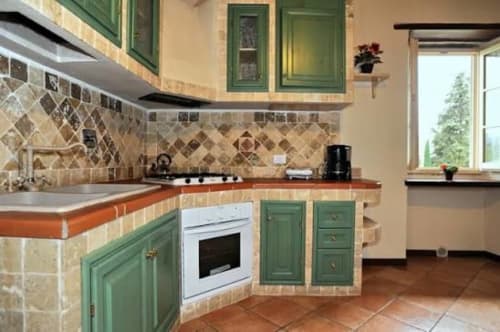 Cucina verde con pavimenti in terracotta nell'appartamento Borgo di Erboli a Cavriglia, Italia