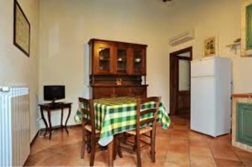 Cucina dell'appartamento Lapo a Borgo di Erboli, Cavriglia con tavolo da pranzo, frigorifero bianco e mobile in legno