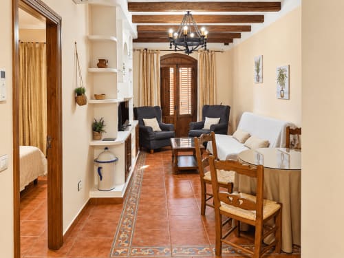 Amplio salón de apartamento de 2 dormitorios en La Posada, Oropesa con vigas de madera, pisos de terracota y mobiliario rústico