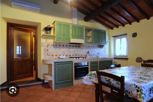 Cucina dell'appartamento Eleonora a Borgo di Erboli B&B a Cavriglia con mobili verde e tavolo da pranzo