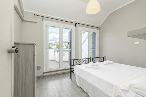 Camera moderna alla ML White House Genova con letto matrimoniale, balconate con vista sulla città e arredi contemporanei