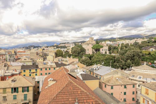 Vista panoramica dei tetti storici e dell'architettura di Genova dall'appartamento ML White House con le montagne sullo sfondo
