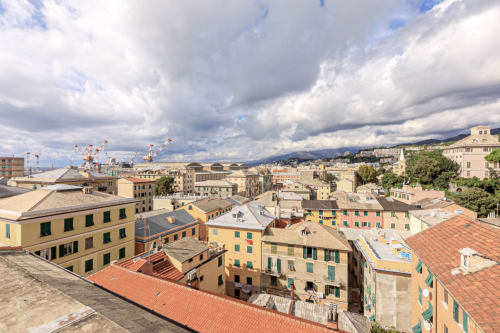 Vista panoramica di Genova da Lavanda House 701, con edifici storici colorati e gru portuali