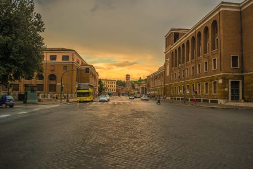 Piazza romana storica al tramonto con edifici color ocra e pavimentazione in sampietrini vicino all'hotel di lusso Trevi House