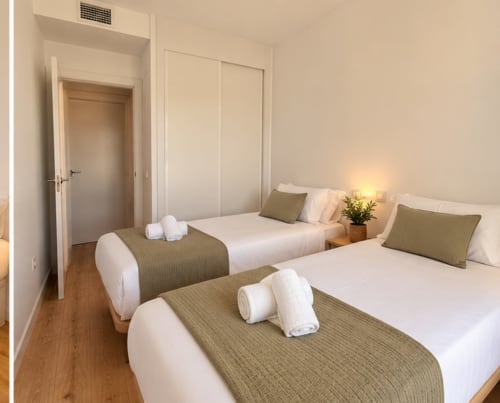 Camas gemelas con mantas oliva en apartamento moderno de Málaga en Sinese Design Homes, con suelos de madera y decoración neutral