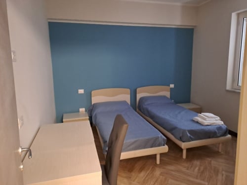 Twin bedroom at Sweet Elite House B&B in Scafati with blue accent wall and wooden beds