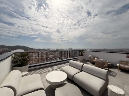 Terraza moderna en la azotea de Sinese Design Homes Málaga con zona de descanso, vistas a la montaña y horizonte urbano
