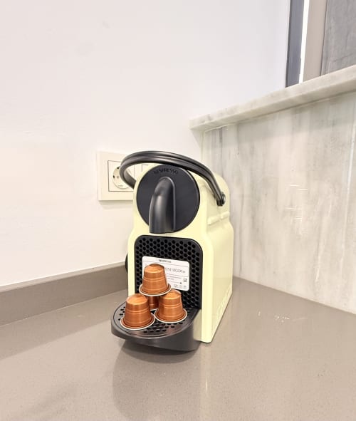Máquina de café Nespresso con cápsulas color cobre en cocina de apartamento malagueño