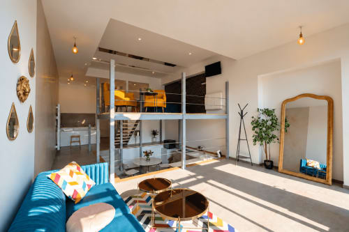 Loft contemporain aux Gîtes Saint Valery En Caux avec mezzanine, sièges bleus, accents bois et lumière naturelle