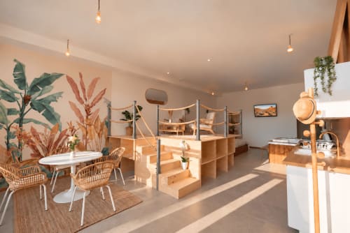 Lumineux loft aux Gites Saint Valery En Caux avec mobilier moderne, plantes, étagères en bois et éclairage suspendu
