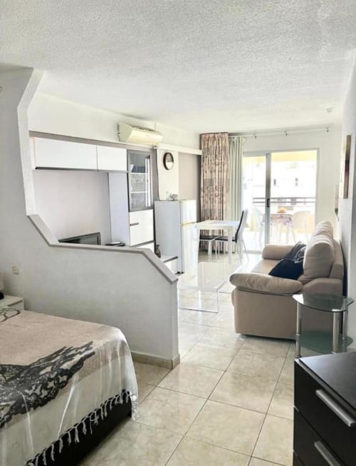 Modern studio apartment in Costa Adeje, Tenerife with living area, kitchenette, bed, and pool view balcony