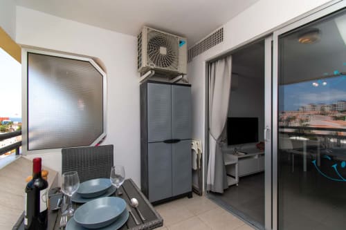 Sunny studio kitchenette in Costa Adeje with dining table, air conditioning, and balcony view in Tenerife