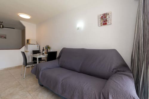 Modern studio apartment living area in Costa Adeje with sofa, work desk, and contemporary furnishings