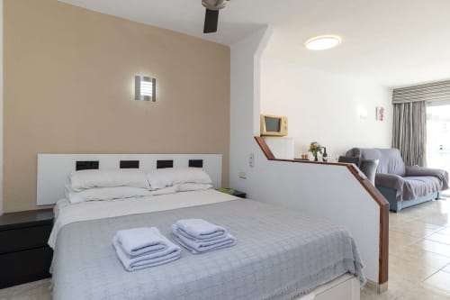 Modern studio apartment in Costa Adeje with bed, sitting area, TV, and balcony access overlooking sea views