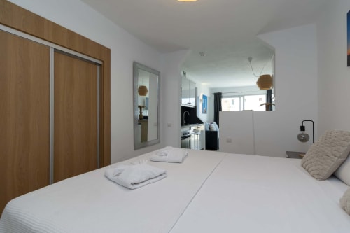 Modern studio apartment bedroom in Costa Adeje, Tenerife with twin beds, mirrored wardrobe, and en-suite bathroom