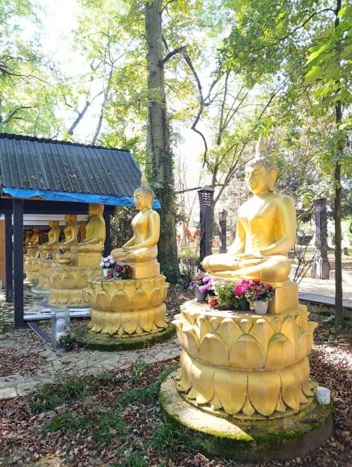 Statues de Bouddha doré en position de méditation lotus au jardin tranquille de l'Hôtel Motelia à Moissy-Cramayel