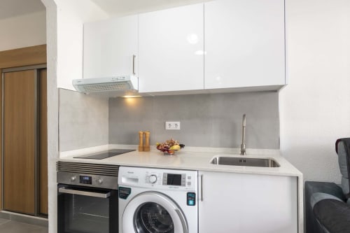 Modern studio kitchen with washing machine, oven, and sink in Costa Adeje apartment