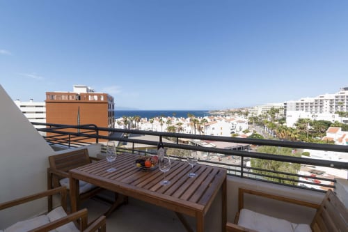 Sea view balcony with dining table overlooking Costa Adeje, Tenerife coastline and Mediterranean blue waters